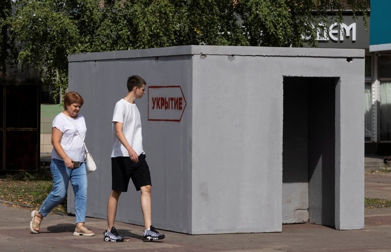 People walk past a reinforced concrete bomb shelter installed in a street in the course of Russia-Ukraine conflict, in Kursk, Russia 