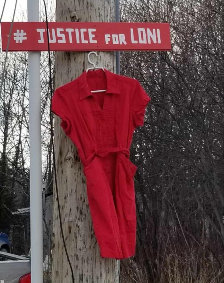 A red dress hanging on a telephone pole.