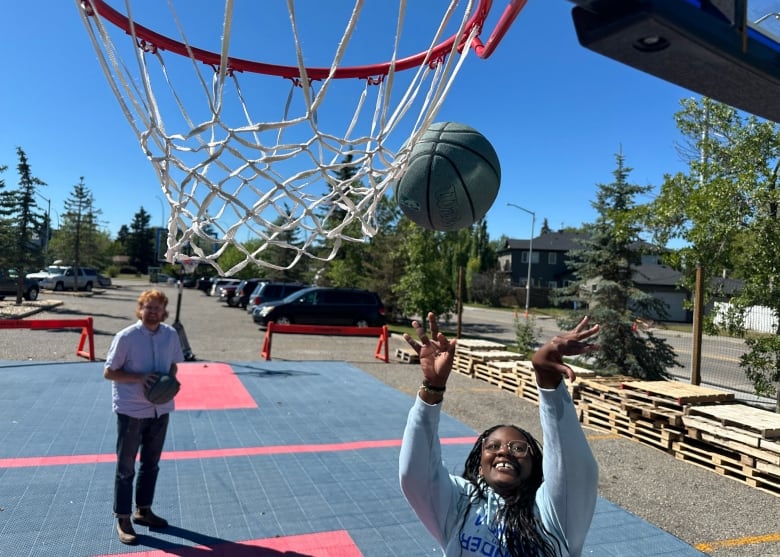 A woman scores a basket.