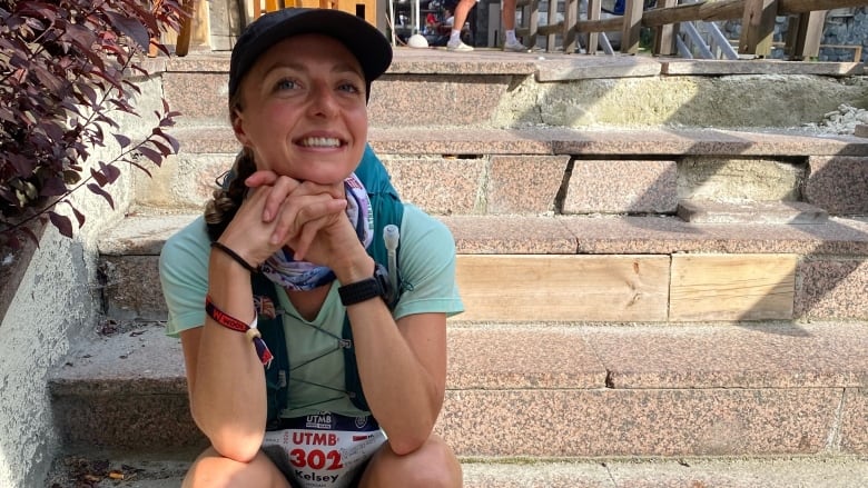 A smiling woman sitting on steps