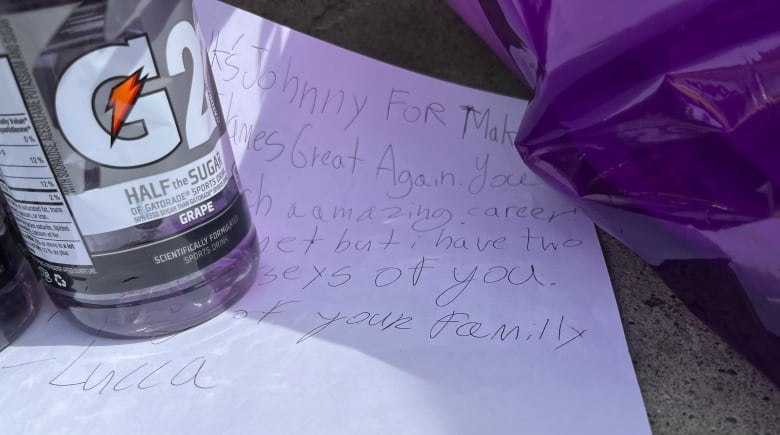 A handwritten letter and a bottle of G2 grape flavoured gatorade.