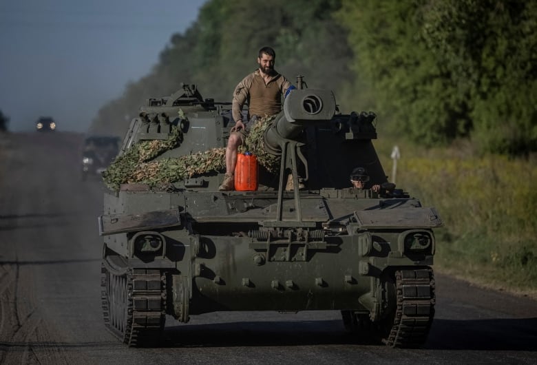 A Ukrainian soldier is seen moving along a road, on top of a self-propelled howitzer, in Ukraine's Sumy region, last month.