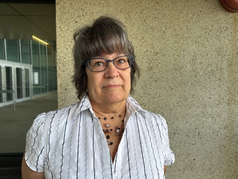 A woman stands outside a court house.