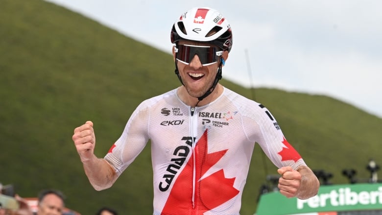 A cyclist pumps his fists in celebration.