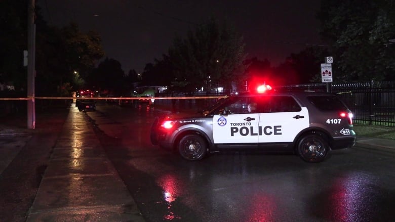 A police car seen at the scene of a crime.