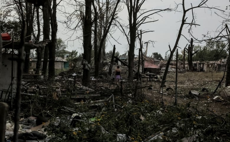 A local resident walks near residential buildings heavily damaged during a Russian military attack.