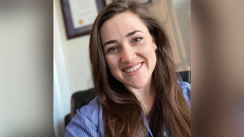 A smiling woman with long brown hair.