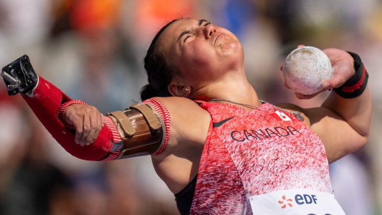 Female Paralympian doing shot put.