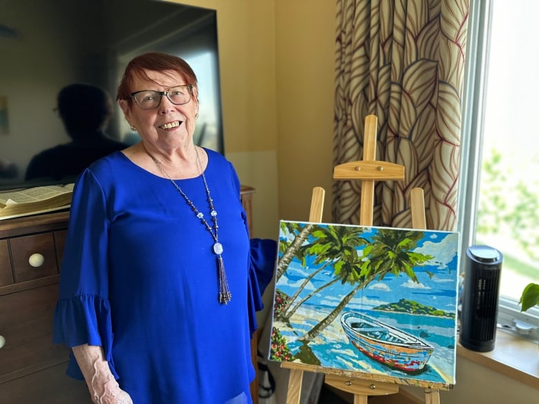 A woman standing next to a painting 