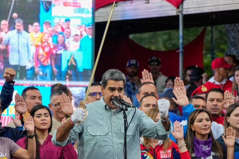 Venezuela's President Nicols Maduro brandishes a sword as his new cabinet takes the oath of office at the presidential palace in Caracas, Venezuela on Wednesday, Aug. 28, 2024.