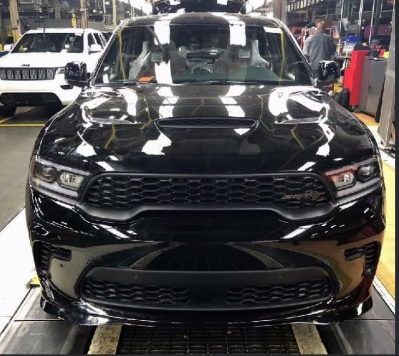 A black SUV on a motor vehicle assembly line shot from the front