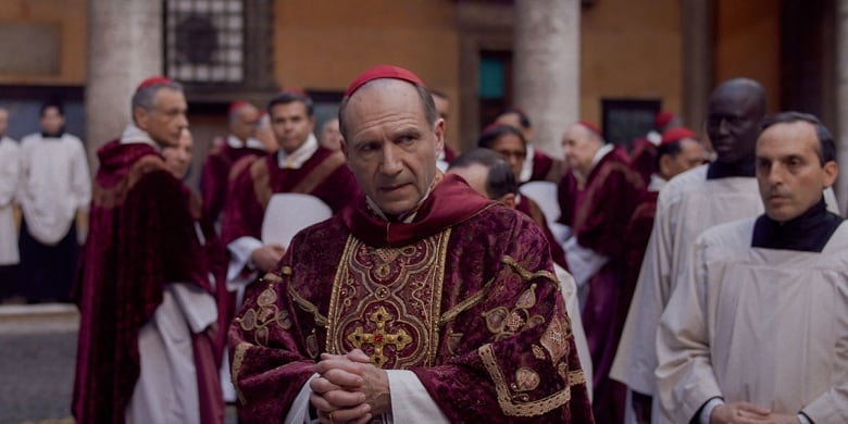 a group of men dressed as Cardinals stand in a marble room.