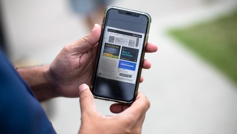 Two hands holding a cell phone with the Ticketmaster app open on it.