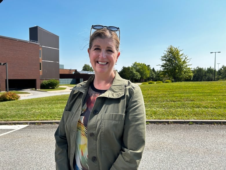 Medium shot of woman smiling at camera on a sunny day