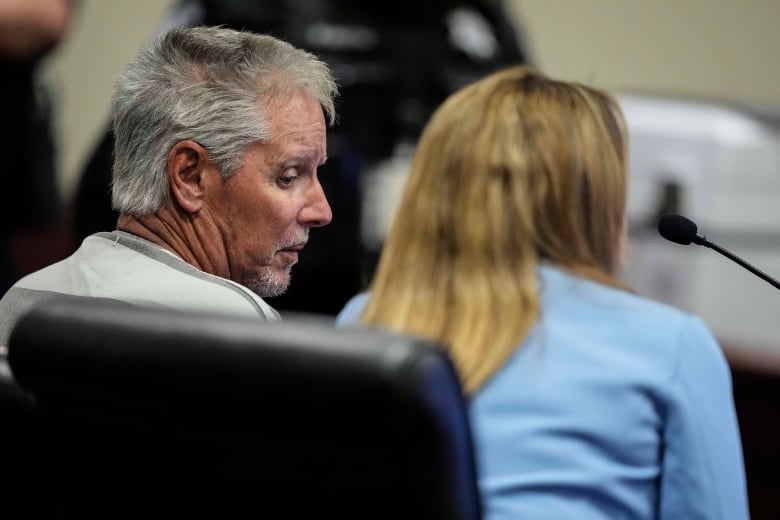 A man appears in court with his lawyer.