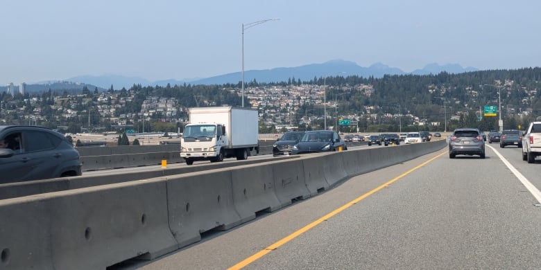 A road is pictured with hazy mountains in the distance.