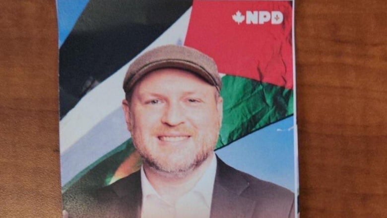 NDP Candidate Craig Sauv's campaign pamphlet depicts him standing in front of a Palestinian flag. 