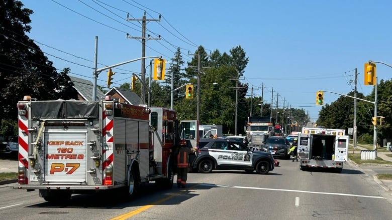 Street closed with emergency vehicles including a fire truck, police cruisers and ambulance