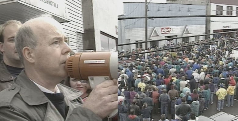 protest sign, man with megaphone and big crowd of people outside a building