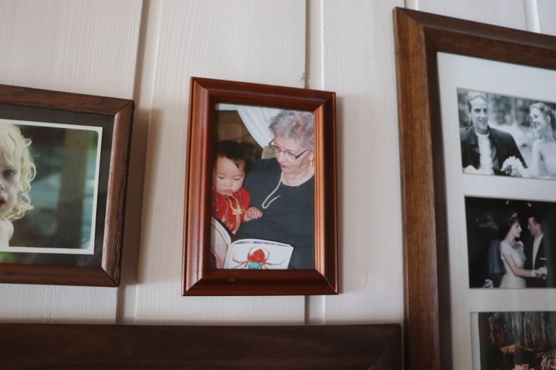 A frames photo of a grandmother holding a toddler reading a book 