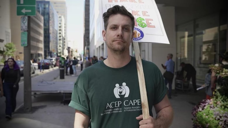 A union leader poses for a photo at a rally outdoors in a city in summer.