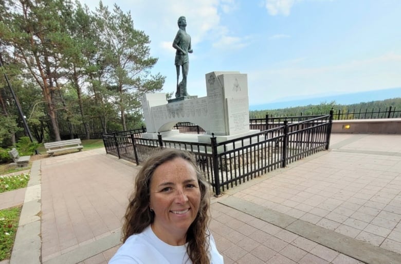 A woman posing with a Terry Fox statue