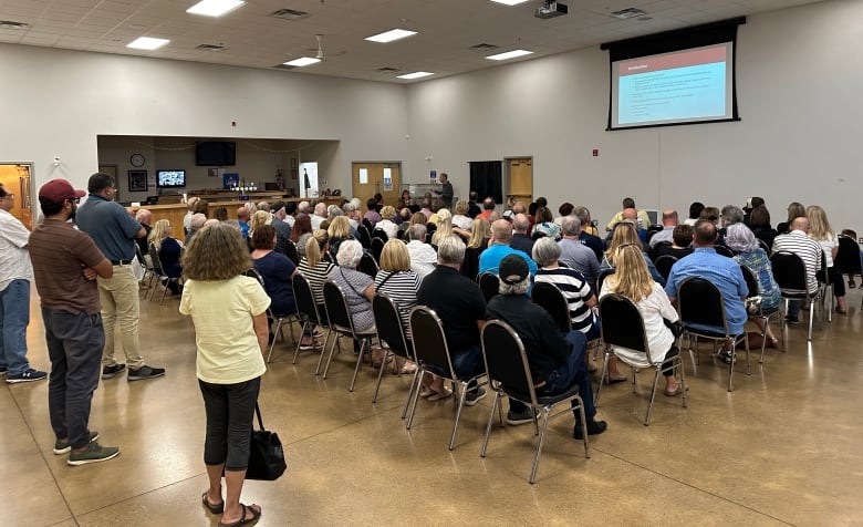 Attendees listen to a presentation at a community meeting.