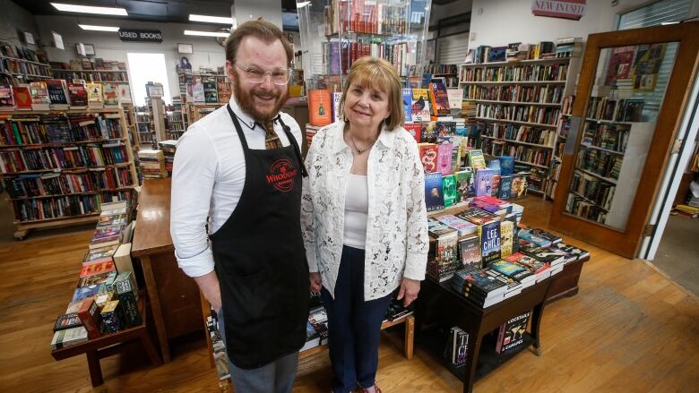 Two people stand inside a bookstore.