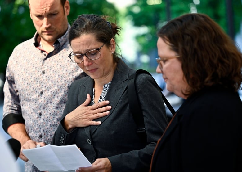 Stephanie Viau, centre, the complainant in the trial of former vice admiral Haydn Edmundson makes a statement to journalists outside the courthouse in Ottawa after Edmundson was found not guilty, on Monday, Sept. 16, 2024. THE CANADIAN PRESS/Justin Tang