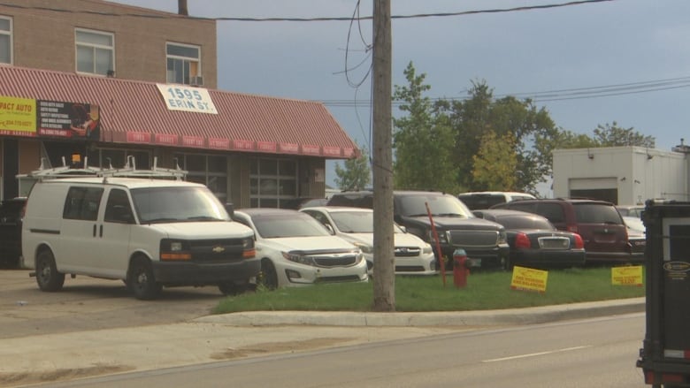 A row of cars are shown in front of a building with a sign that says 