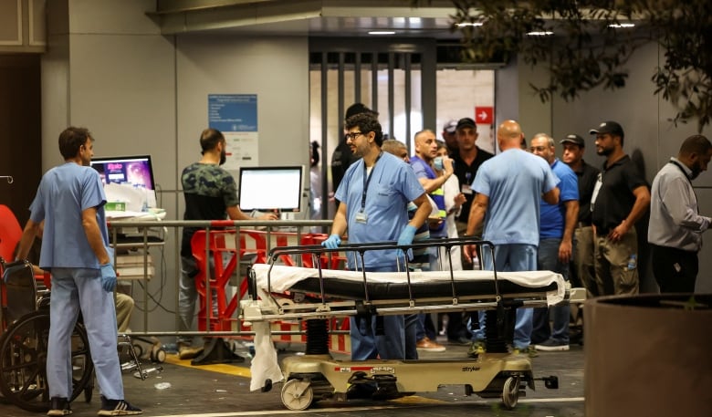 A personnel of American University of Beirut Medical Center (AUBMC) is seen standing next to an empty stretcher.