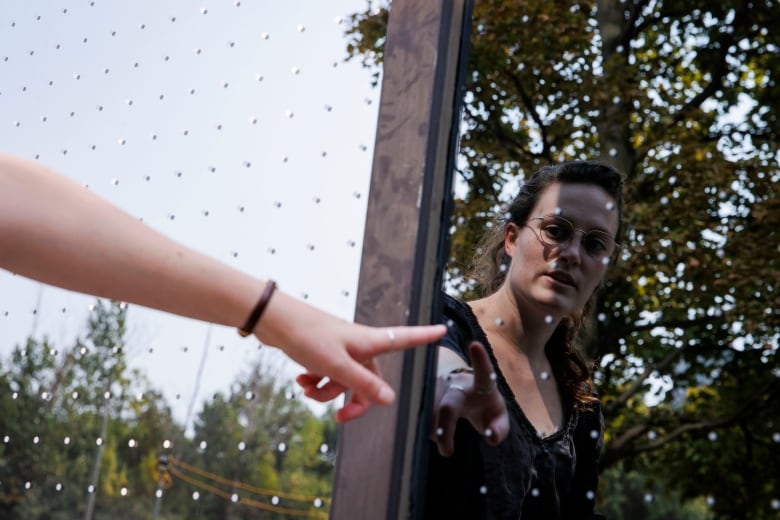 woman pointing at dots on glass