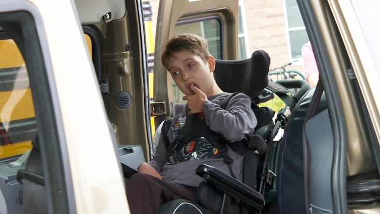 A child in a wheelchair sits inside wheelchair van. 