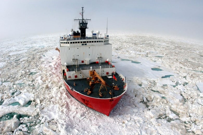 A ship breaks through icy water.