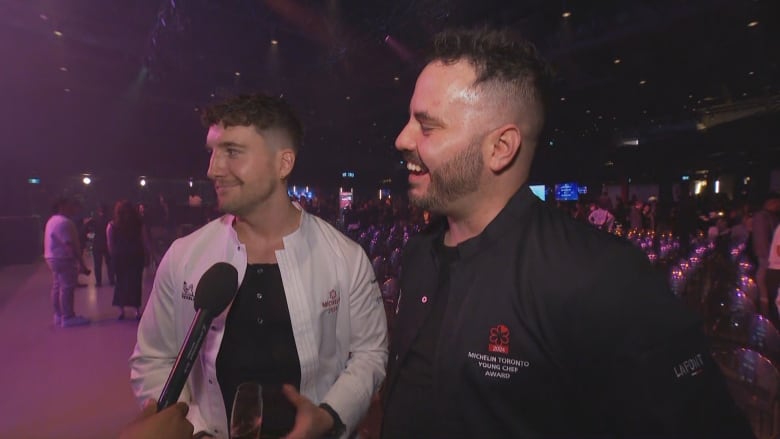 Two young white men speak into a reporter's microphone at the 2024 Michelin Guide Toronto & Region selection Wednesday.