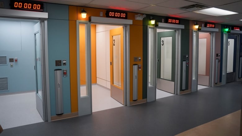 A row of cubicles with a digital counter above each door.