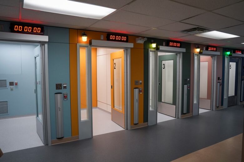 A row of cubicles with a digital counter above each door.