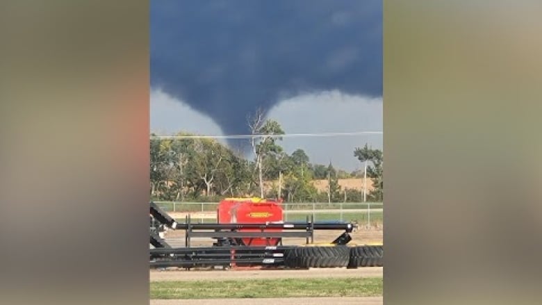 A tornado forms during the afternoon near a farm.