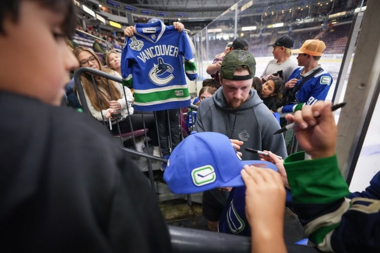 A hockey player signs autographs.