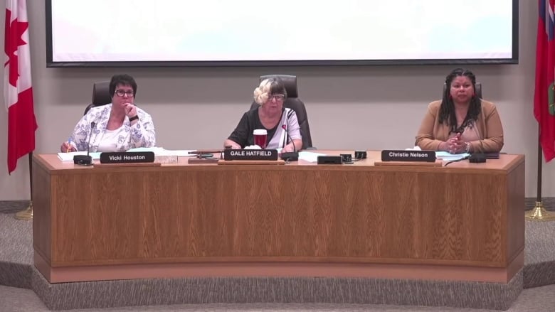 Three woman head a board meeting.