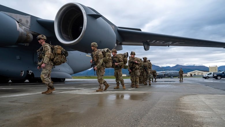 Soldiers are seen walking beside a large airplane.