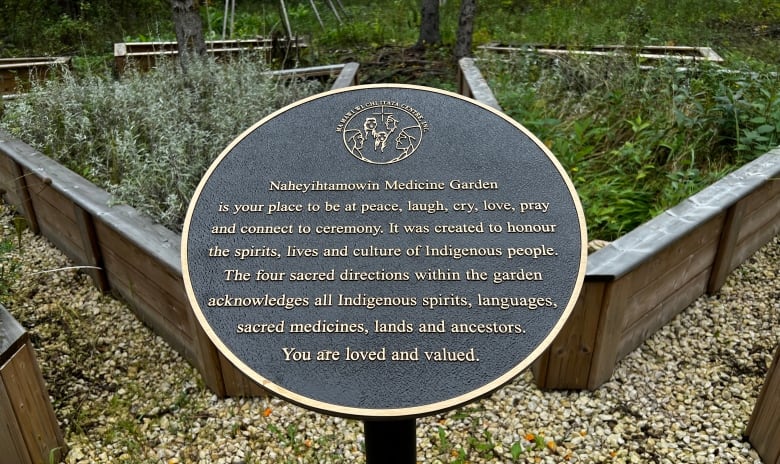 A sign is pictured in a garden.