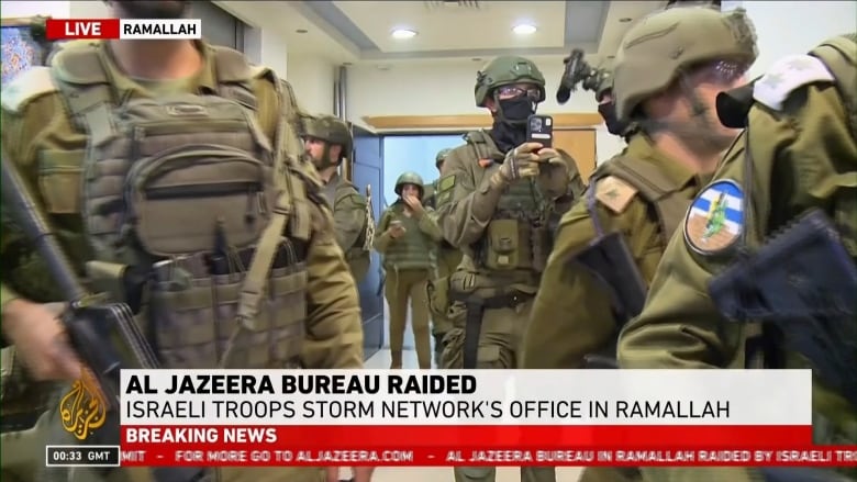 Soldiers enter an office.