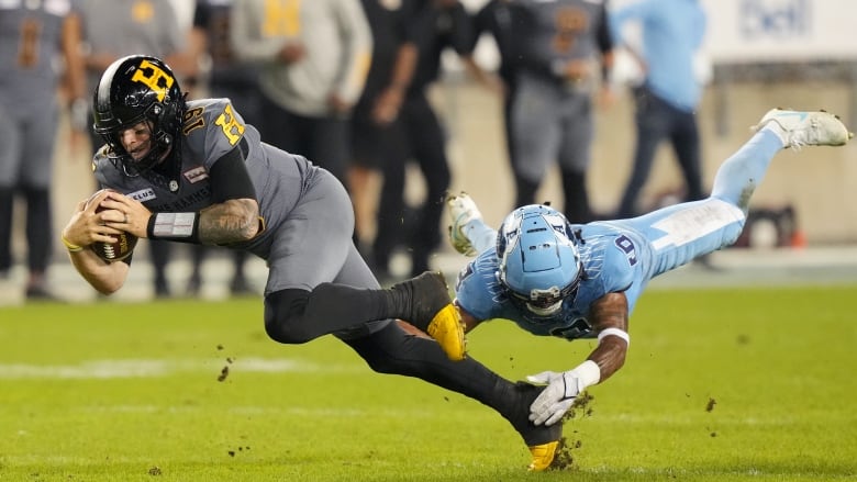 Hamilton Tiger-Cats quarterback Bo Levi Mitchell (19) is tackled by Toronto Argonauts defensive back Royce Metchie (9) during second half CFL football action in Toronto on Friday, September 20, 2024. 