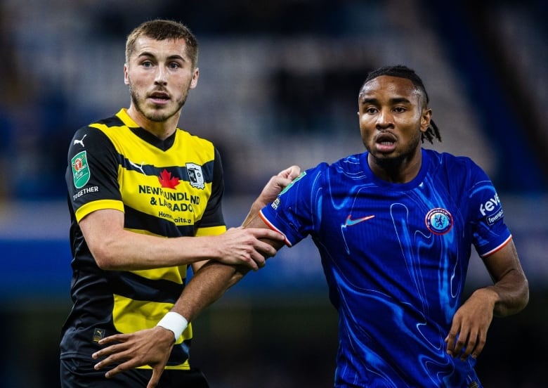 Two soccer players battle for place on the field.