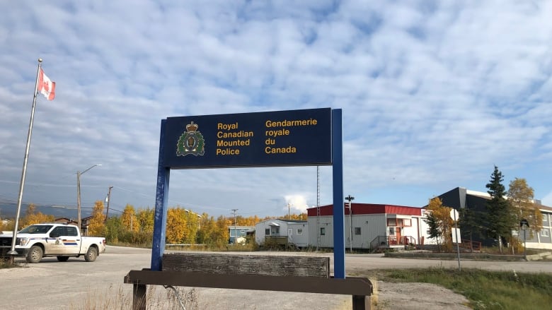 An RCMP detachment sign in front of a town 