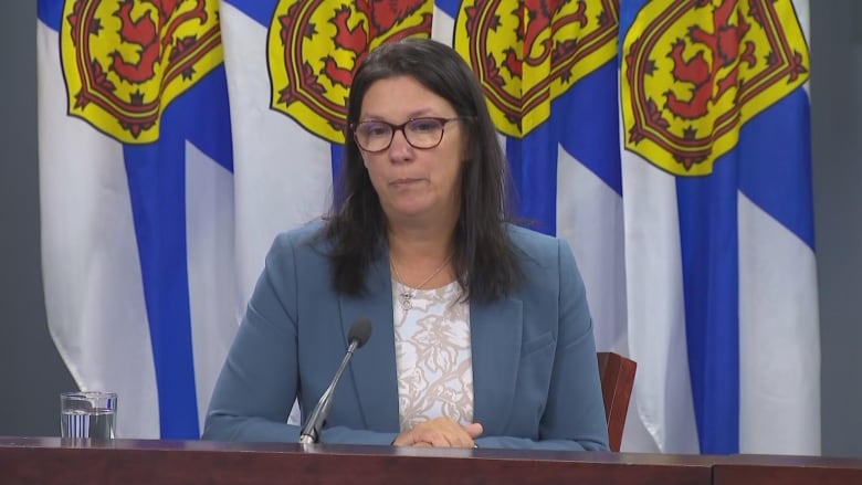 Woman with Nova Scotian flags behind her. 