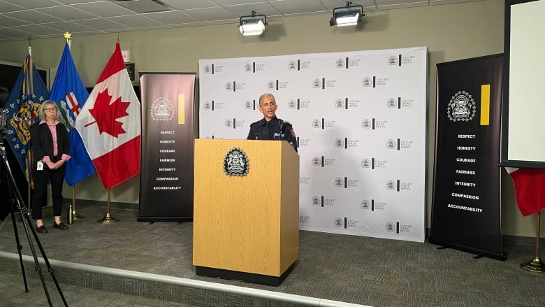 a police officer stands at a podium in front of a microphone.