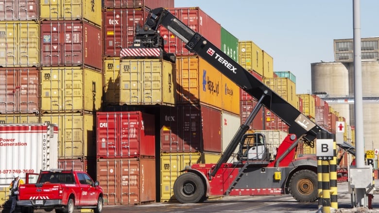 Trucks stacking shipping containers at the Port of Montreal.