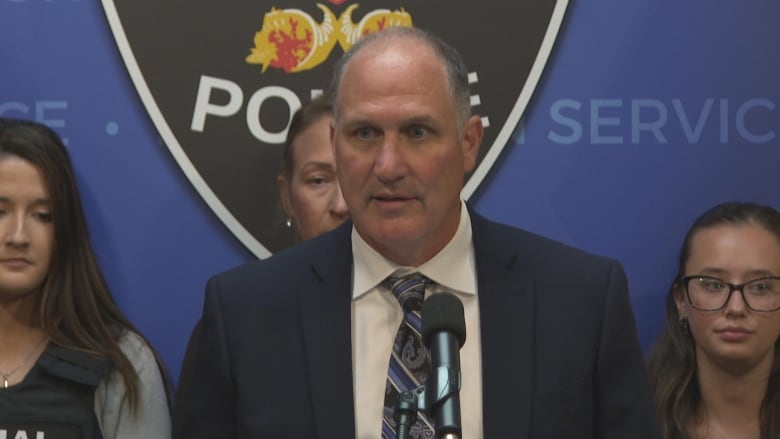 Staff Sgt. Richard Sieberer standing in front of windsor police logo